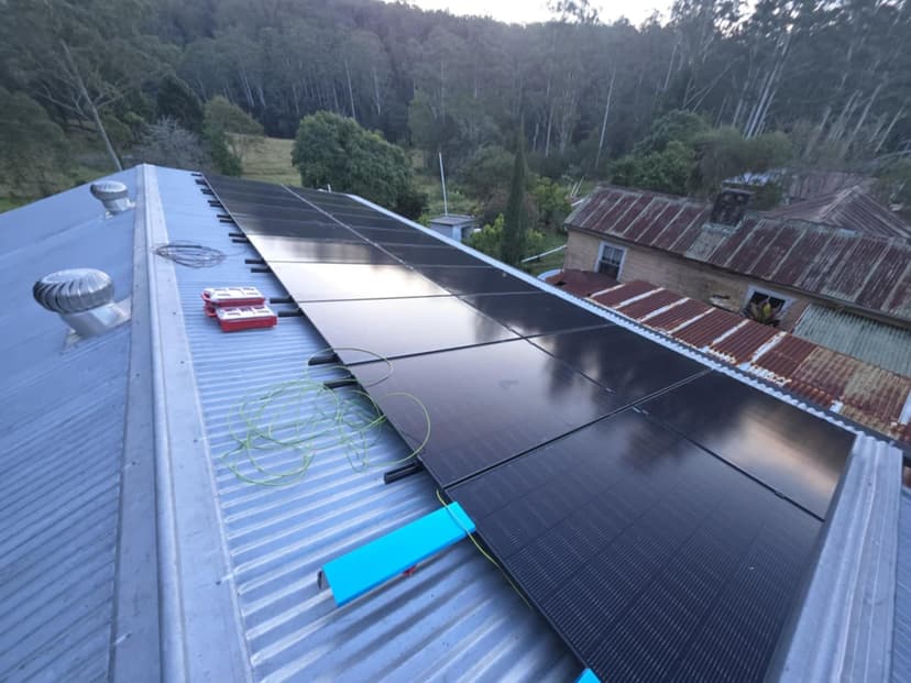 Complete solar panel installation on residential roof with rural background